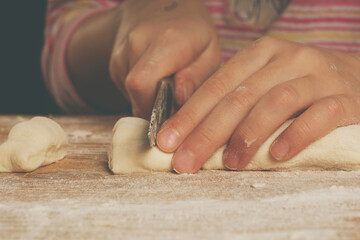 Young girl with a knife making homemade dumplings. Dumplings with potatoes and cheese stuffing. National food, eating, delishion, diet concept.