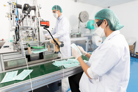 Woman Factory Worker Are Producing Medical Face Masks And Checking Of Quality From Machine