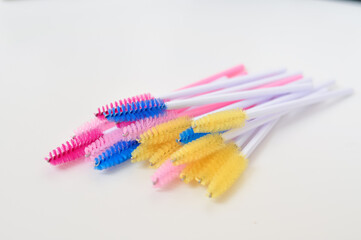 colored brushes for lash extensions in beauty salon,materials for lashmaker on white background,...