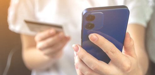 Using smartphone for online shopping, banner. Credit card internet pay concept background. Woman hand with credit card and mobile phone close-up