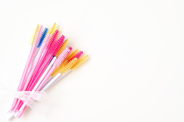 colored brushes for lash extensions in beauty salon,materials for lashmaker on white background,...