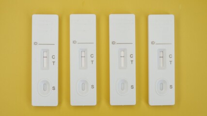 4x Covid19 rapid antigen tests on yellow background