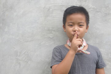 Boy with finger on lips No sound silent gesture Secret