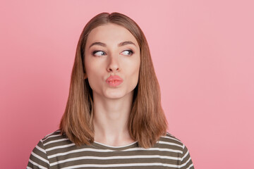 Portrait of flirty coquette lady blow air kiss look side empty space on pink background