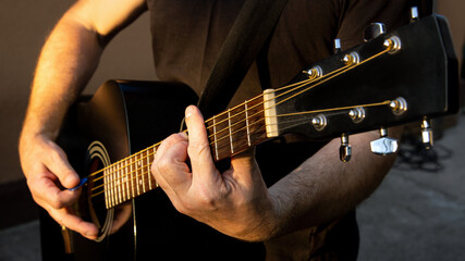 A man playing a melody on a guitar. Close-up