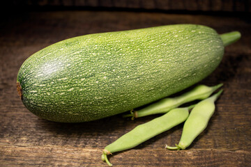 Zucchini and string beans lying on a wooden table.Fresh bright vegetables on a wooden background.