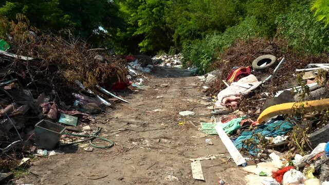 rubbish heap in the street near green trees