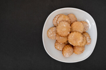 Appetizing round shortbread on white plate. Homemade shortcake. Top view. Copy space