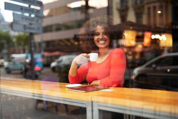 Young woman at cafe drinking coffee. Beautiful African girl on coffee break.