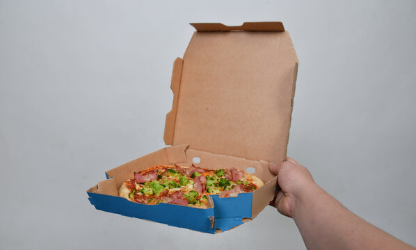 hand h&auml;lt frisch elecker epizza in karton lieferung kontaktlos zustellung lieferdienst pizzabote
