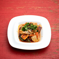 Exotic oriental dish with crab meat. Plate of pan-asian food on pink wooden background. Soft focus. Square format. Copy space.