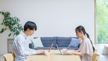家で仕事をする若い夫婦・カップル