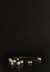 Black podium on the black background with pearls. Podium for product, cosmetic presentation....