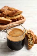 Tasty cantucci and cup of aromatic coffee on white wooden table. Traditional Italian almond biscuits
