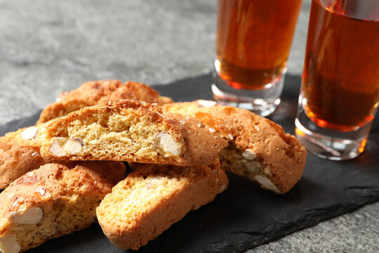 Tasty cantucci and glasses of liqueur on grey table, closeup. Traditional Italian almond biscuits