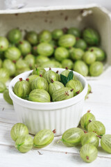 Set of organic gooseberry. Gooseberries fruits in a cup. Green gooseberry over rustic wooden background. Sweet and juicy berry.