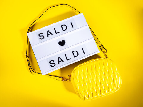 Fashion sale concept with lightbox Italian text and leather bag on yellow