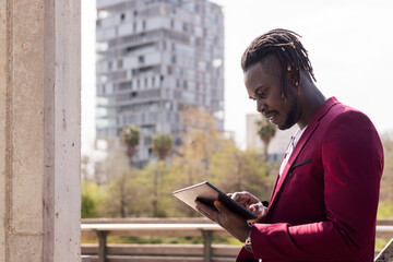 black man using a tablet outdoors in the city