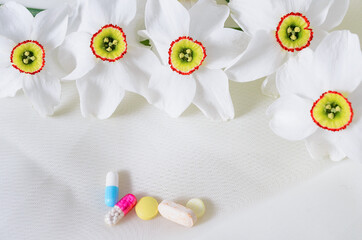 Obraz na płótnie Canvas Treatment for various diseases. Tablets with flowers on a white background