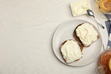 Bread with cream cheese on white wooden table, flat lay. Space for text