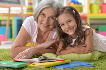 Cute grandmother with granddaughter with books