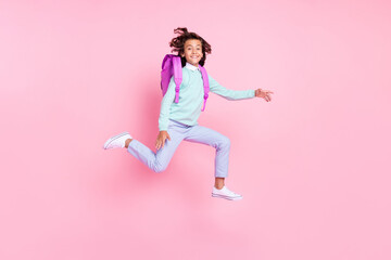 Photo of active sporty boy jump hurry back to school wear rucksack teal shirt isolated pink color background