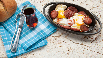 Fried eggs with sausage in pan
