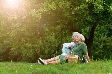 Senior couple sitting on the grass in the park