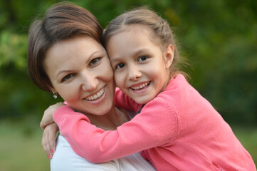 Happy mother and daughter smiling outdoors