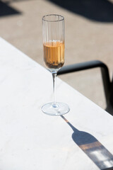 glass with liqueur on a summer terrace casting shadow on the table