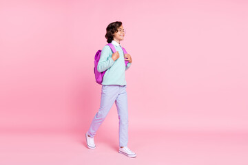 Profile photo of positive schoolboy stroll empty space wear bag specs teal shirt isolated pink color background