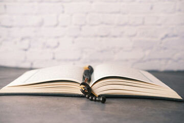 Holy book Quran and rosary on table, close up.