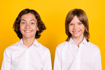 Photo of two candid glad schoolboys shiny white smile wear white shirt isolated yellow color background