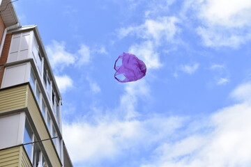 a plastic bag flying in the air between residential buildings