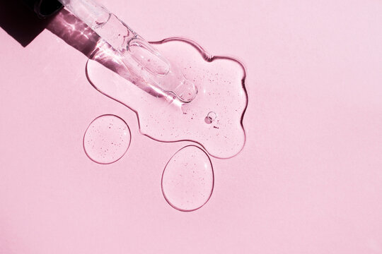 Hyaluronic acid with a dropper on a pink background. Side view.