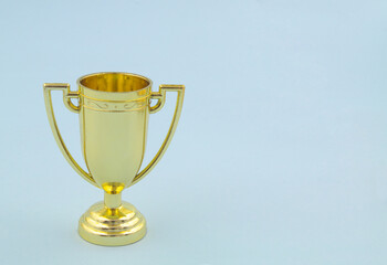 Champion golden trophy cup on blue background with copy space for text