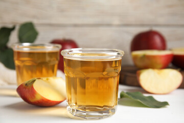 Glass of delicious apple cider on white table. Space for text