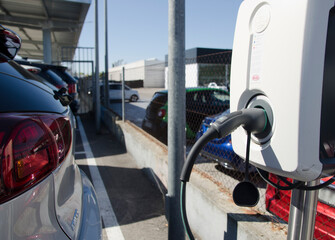 Madrid, Spain. 6th August. EV Car or Electric vehicle at charging station cable supply with blue...