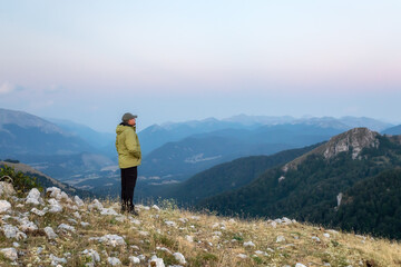 Hiker meditates amidst the mountain landscape.