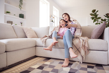 Obraz premium Full length photo of cheerful happy positive pretty sisters siblings watch tv sit sofa indoors inside house home