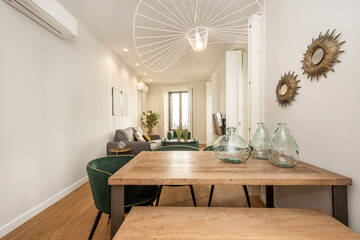 Untreated wood dining table with glass accents on top in a vacation rental apartment with many bay...