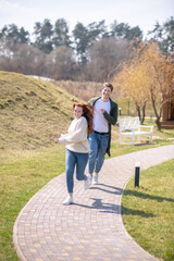 Obraz premium Woman and man running in playful mood in nature