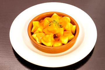 Popular Madrid tapa of patatas bravas served in a clay pot