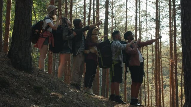 Portrait of creative young people tourists taking selfie with smart phone camera in green forest. Modern technology and photography concept.
