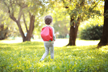 Children with briefcases for a walk in the park. School break. The beginning of the children's studies.