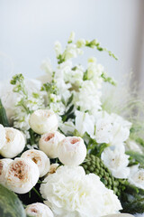 A wedding bouquet of white roses and eucalyptus on gray background.The bride's morning preparations. Details of a stylish European wedding day.