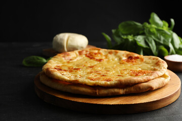 Delicious khachapuri with cheese on black table, closeup