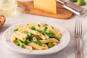 Pasta with green peas, broccoli and parmesan cheese.