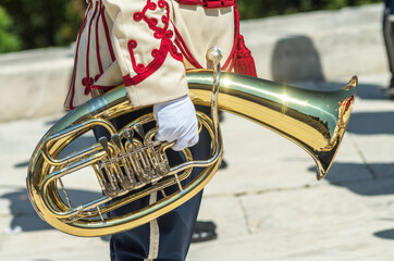 Golden tube. Scene, Shipka. A man is playing the tuba. A musician from a military band holds a tuba. Military parade uniform. A police band is playing on Shipka Peak, Bulgaria.