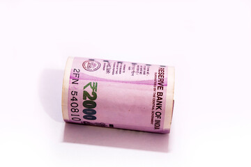 Indian two thousand rupees rolled up banknote isolated on white background.